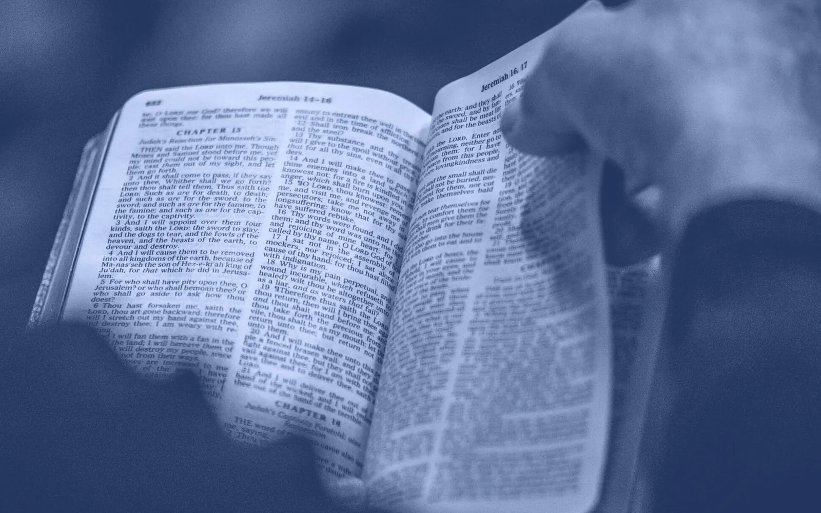 An open King James Bible held in both hands, turned to Jeremiah 16–17 — 'I the LORD search the heart'