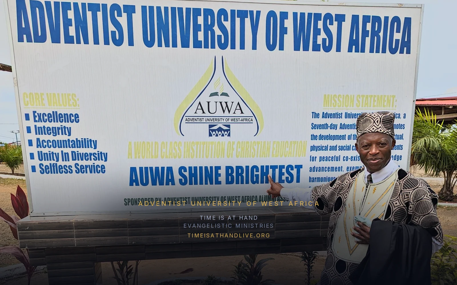 Devon Searchwell pointing to the Adventist University of West Africa sign