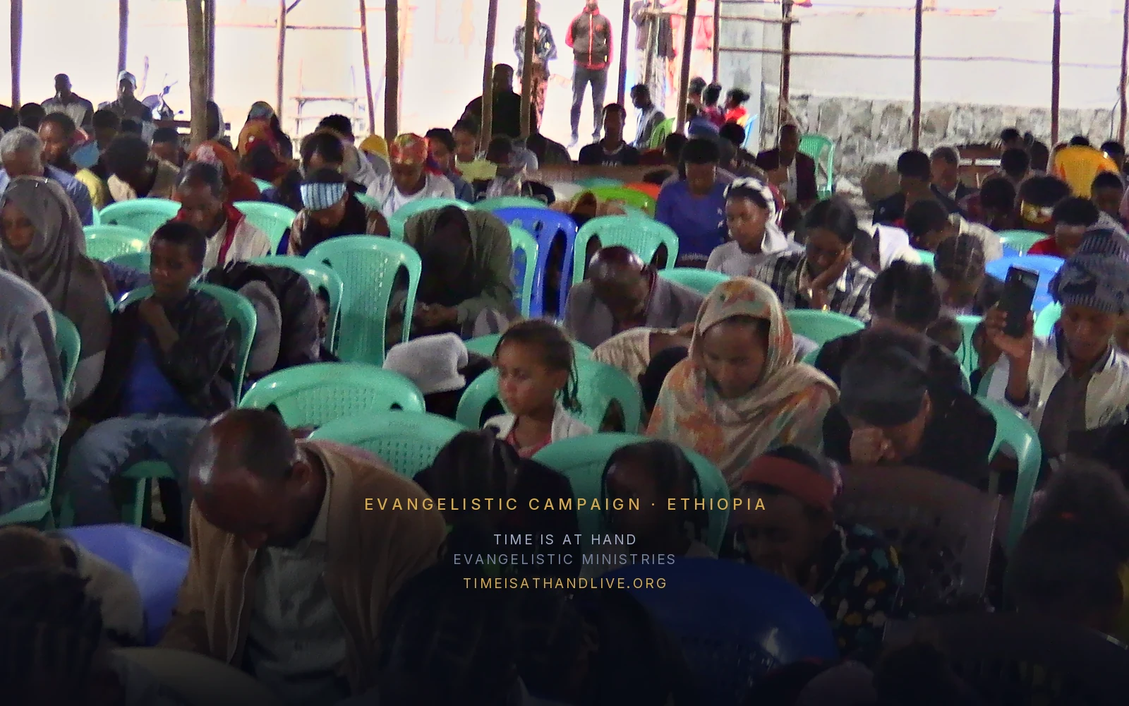 The congregation gathered under the shelter, heads bowed in prayer