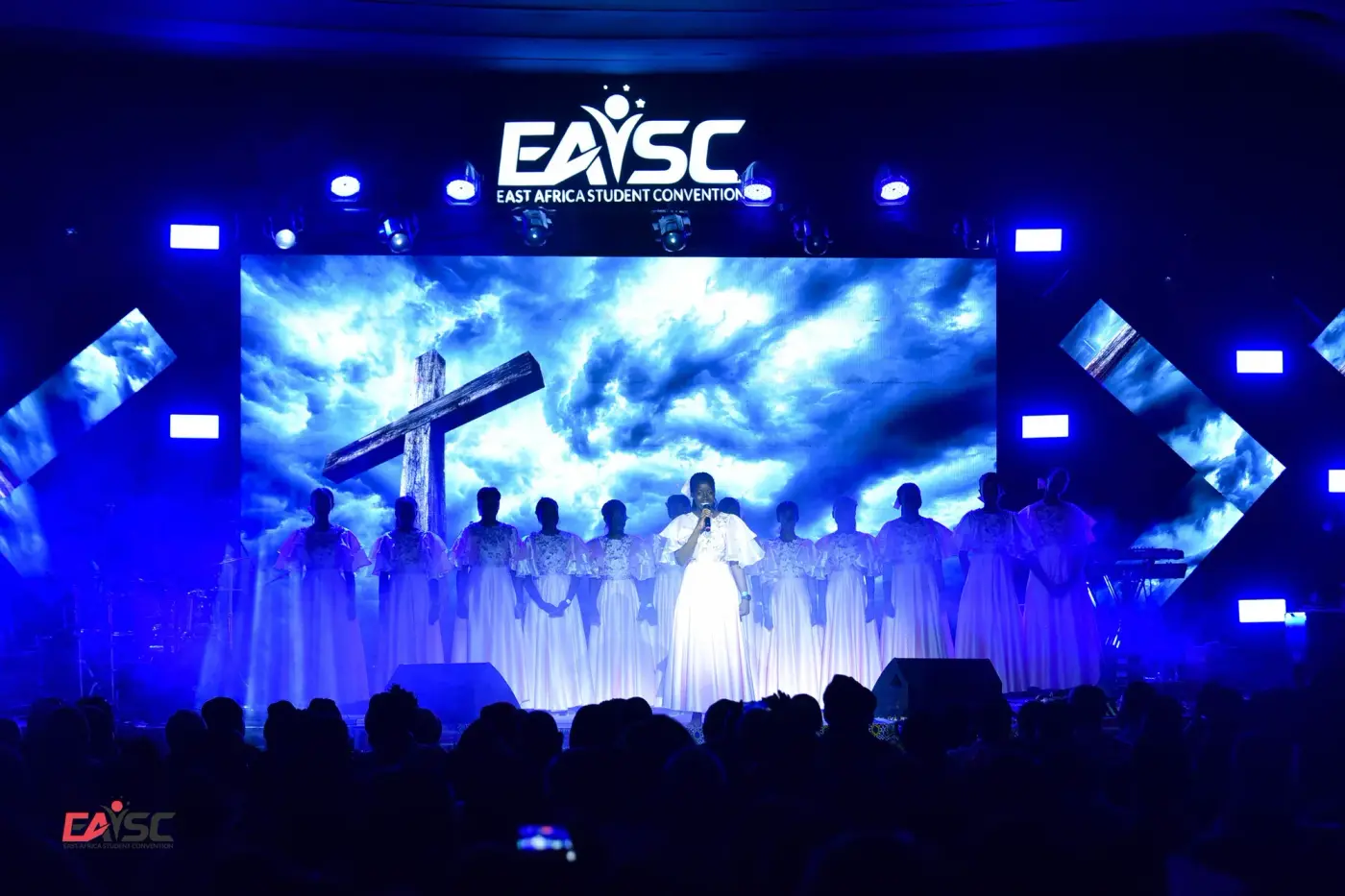 Choir on stage beneath a cross at the East Africa Youth Student Convention